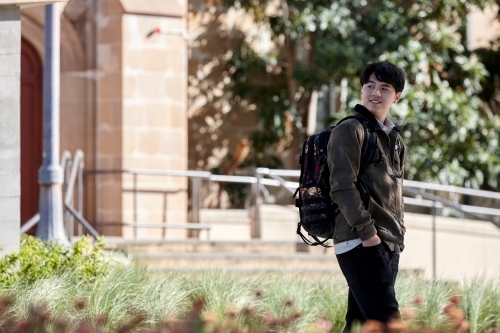 Young Asian university student walking on-campus - Australian Stock Image