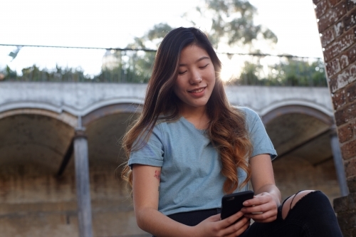 Young Asian woman enjoying time outdoors at enclave - Australian Stock Image