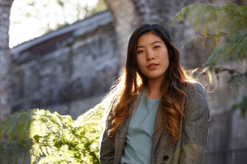 Young Asian woman enjoying time outdoors at enclave - Australian Stock Image