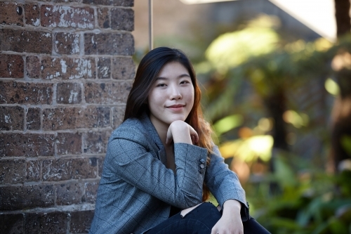 Young Asian woman enjoying time outdoors at enclave - Australian Stock Image