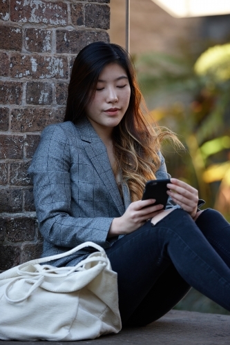 Young Asian woman enjoying time outdoors at enclave - Australian Stock Image