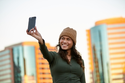 Young Asian woman having fun with mobile phone in city - Australian Stock Image
