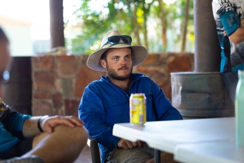 young bloke sitting with mates having a beer - Australian Stock Image