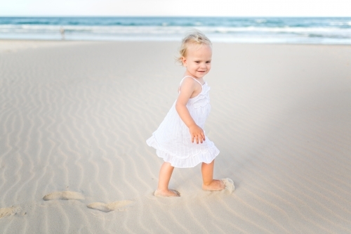 Young blond girl playing at the beach