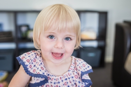 Young blonde girl at home smiling - Australian Stock Image