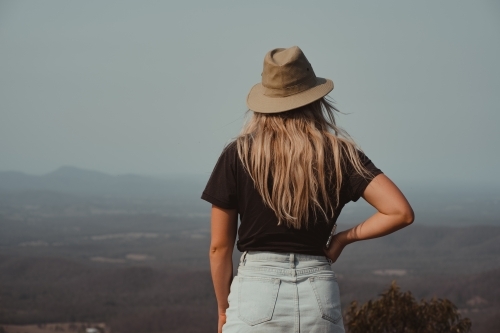Young blonde woman enjoying the view at the top of a mountain - Australian Stock Image