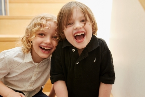 Young boy and girl smiling together indoors - Australian Stock Image