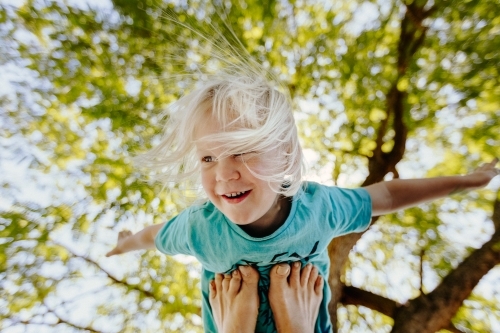 Young boy being held up in the air on feet