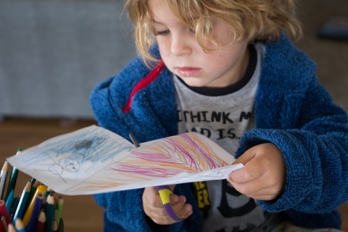 Young boy cutting picture - Australian Stock Image