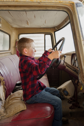 Young boy driving an old international truck - Australian Stock Image