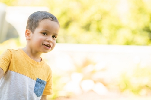 Young boy happily playing outside - Australian Stock Image