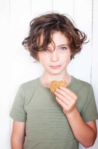 Young boy holding biscuit