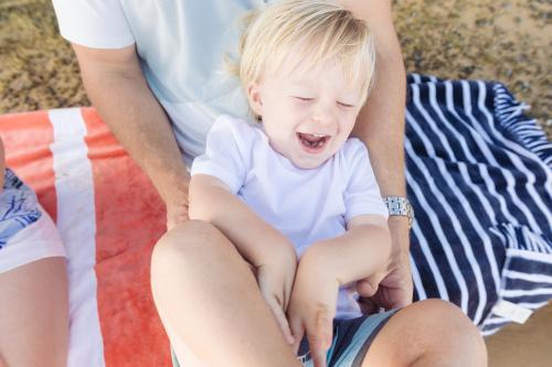 Young boy laughing as dad tickles him - Australian Stock Image