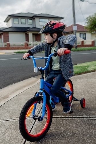 Young boy on his bicycle wearing a bike helmet, cycling around suburban Melbourne