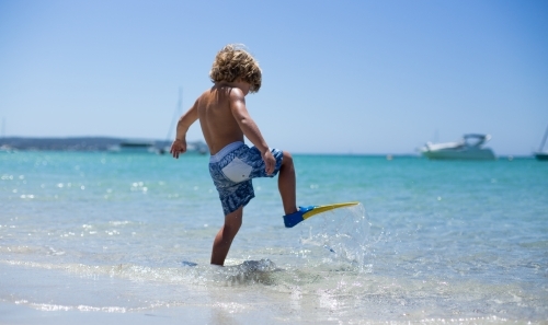 Young boy playing at beach - Australian Stock Image