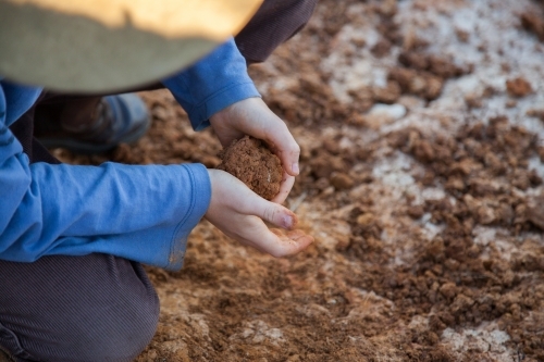 Young boy rolling clay in his hands