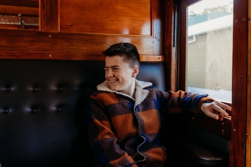 Young boy sitting beside window on train - Australian Stock Image