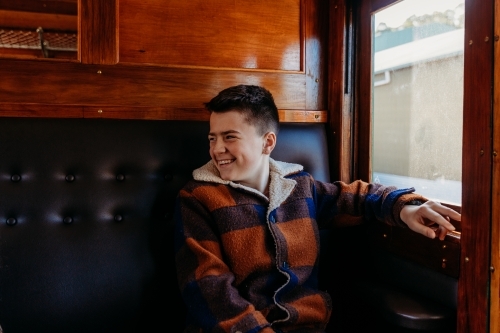 Young boy sitting beside window on train
