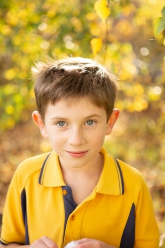 Young boy smiling at camera in yellow school uniform