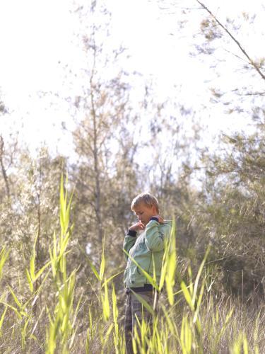 Young boy standing in the bush - Australian Stock Image