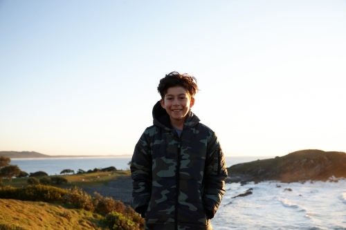 Young boy wearing camo jacket on sunrise - Australian Stock Image