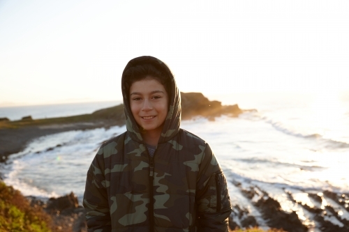Young boy wearing camo jacket on sunrise - Australian Stock Image