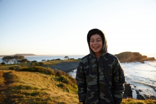 Young boy wearing camo jacket on sunrise - Australian Stock Image