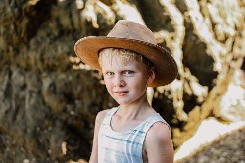 Young boy wearing full bream hat outdoors in summer - Australian Stock Image