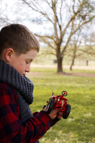 Young boy with an antique red model tractor - Australian Stock Image