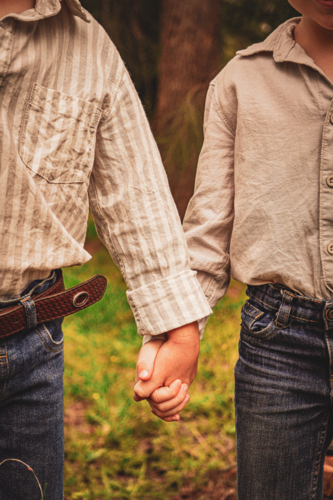 young boys holding hands - Australian Stock Image