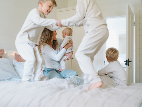 Young boys playing on the bed jumping - Australian Stock Image