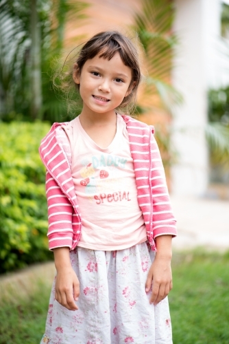Young brown haired girl standing outdoors - Australian Stock Image