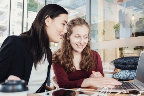 Young business women having casual meeting at coffee shop - Australian Stock Image