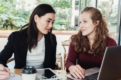 Young business women having casual meeting at coffee shop - Australian Stock Image