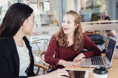 Young business women having casual meeting at coffee shop - Australian Stock Image