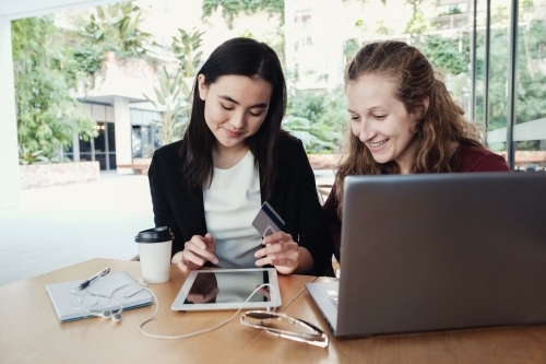 Young business women having casual meeting at coffee shop - Australian Stock Image