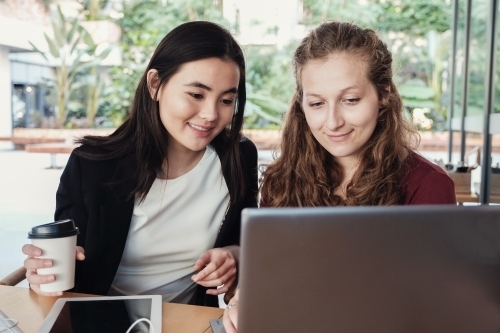 Young business women having casual meeting at coffee shop - Australian Stock Image