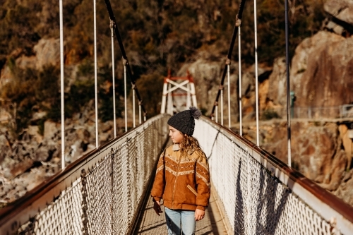 Young child walking across bridge on bush walk - Australian Stock Image