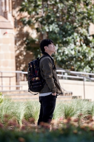 Young Chinese student outdoors with backpack - Australian Stock Image