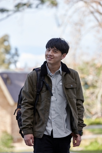 Young Chinese student outdoors with backpack - Australian Stock Image