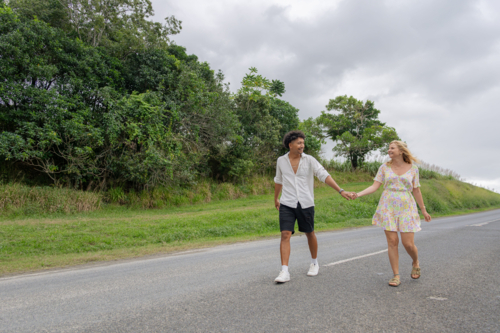 Young couple holding hands walking on the road - Australian Stock Image