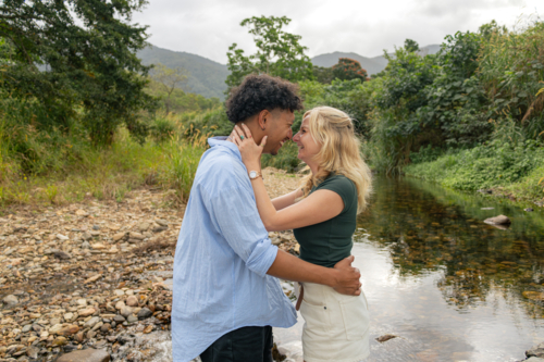 Young couple laughing and embracing at a creek in far north Queensland - Australian Stock Image