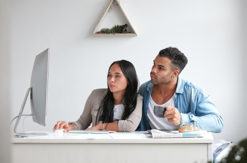 Young couple searching online together over breakfast