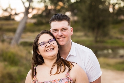 Young couple standing cheek to cheek smiling happy - Australian Stock Image