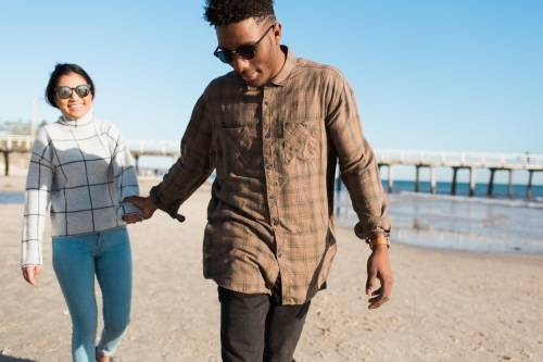 Young couple walking together on the beach - Australian Stock Image