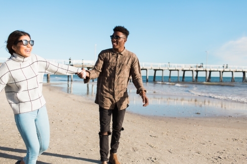 Young couple walking together on the beach - Australian Stock Image