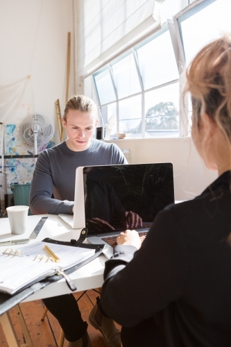 Young creative couple hard at work in their studio - Australian Stock Image