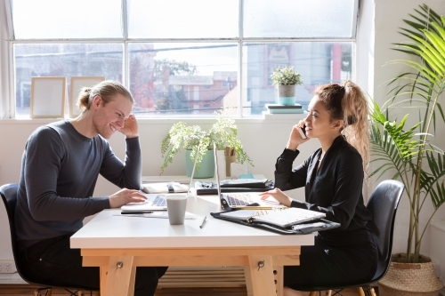 Young creatives working at a desk in a studio - Australian Stock Image