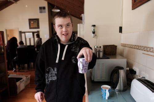 Young Disabled Man Serving a Cup of Coffee - Australian Stock Image