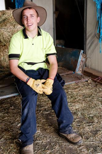 Young Farmer Seated in a Shed - Australian Stock Image